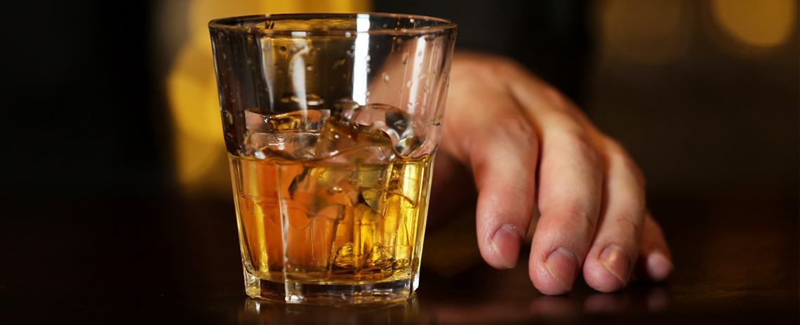 Man's hand holding a glass of scotch Foothill Dental Care in Livermore