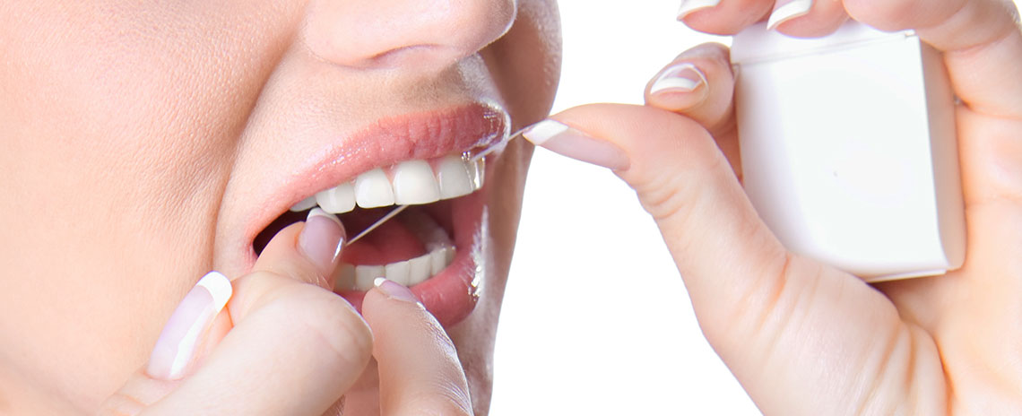 Women flossing her teeth at Foothill Dental Care in Livermore