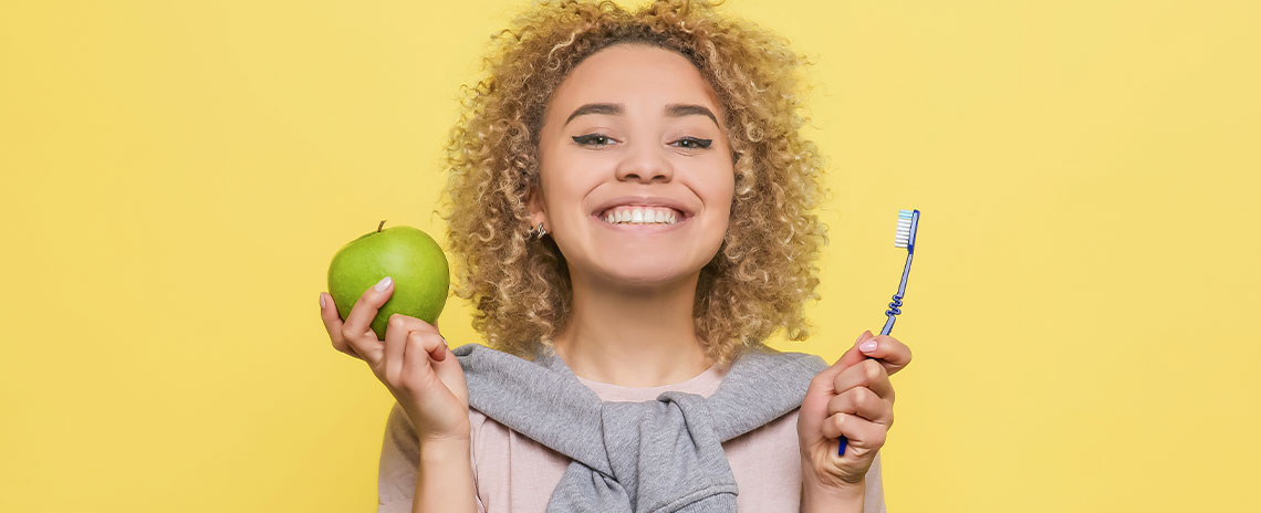Woman eating apple to prevent tooth decay in Livermore